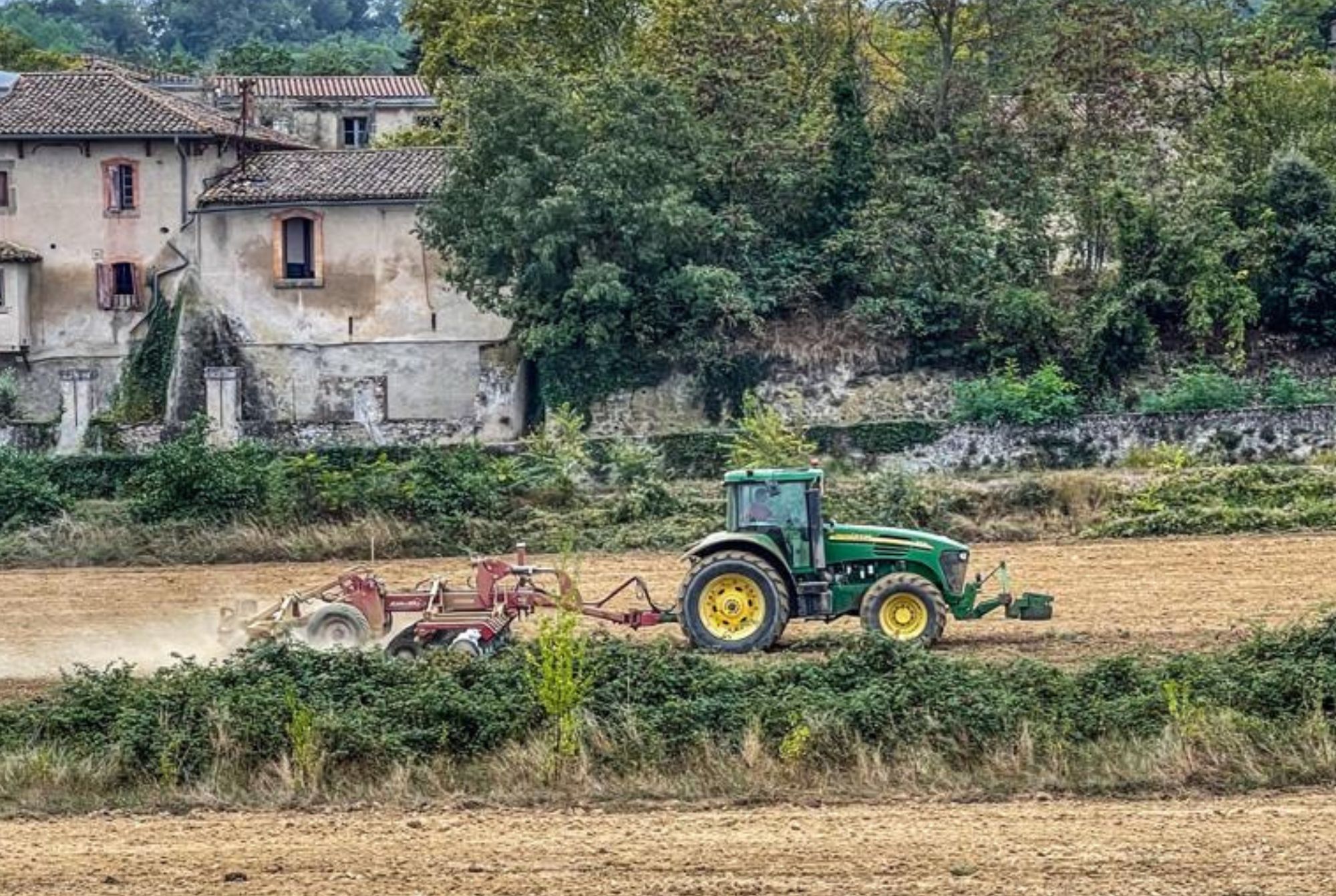 Un agriculteur sur son tracteur, à Roullens dans les plantations de NECTAR.